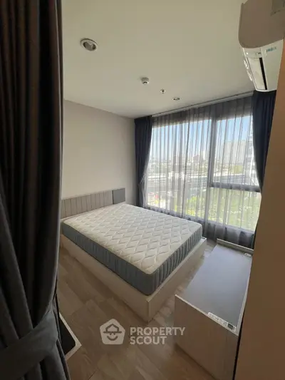 Modern bedroom with large window and natural light, featuring a comfortable bed and sleek design.