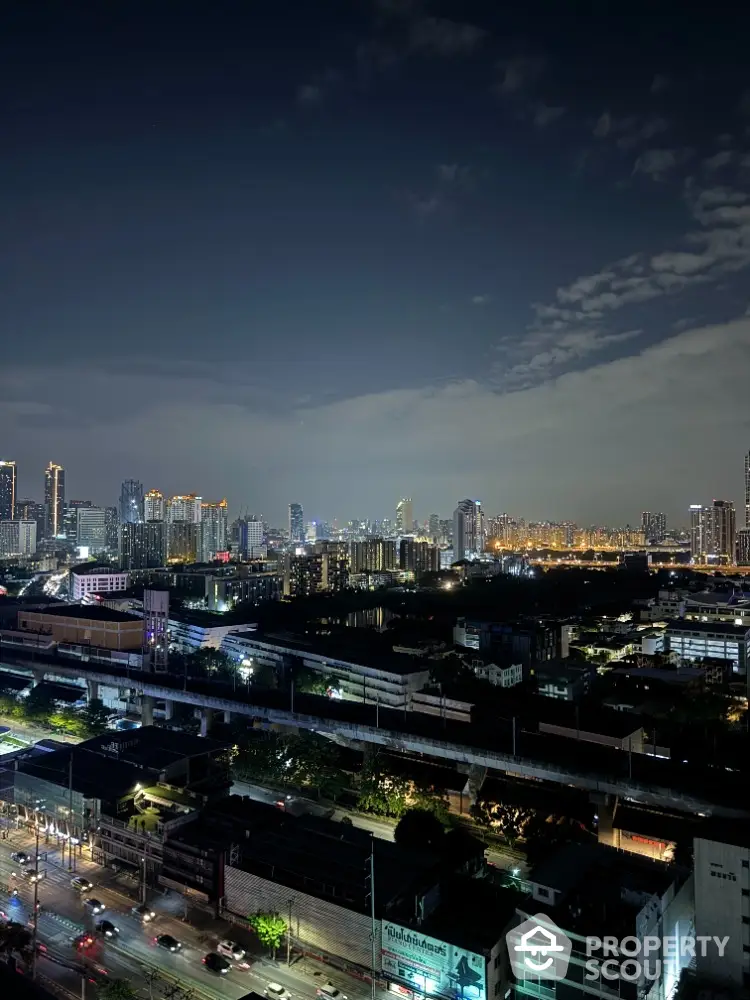 Stunning city skyline view at night with illuminated buildings and vibrant city lights.