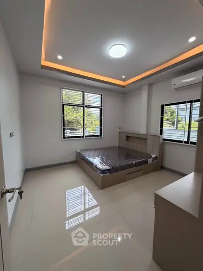 Modern bedroom with sleek design and large windows offering natural light.