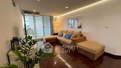 Spacious living room with cozy seating and balcony access in modern apartment.
