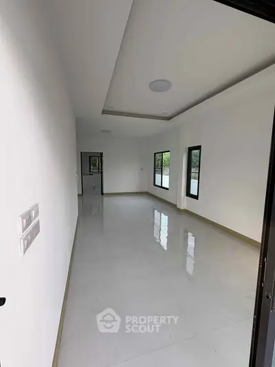 Spacious unfurnished room with large windows and glossy tile flooring