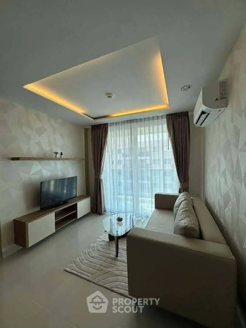 Modern living room with stylish ceiling lights, large window, and cozy furniture in a contemporary apartment.