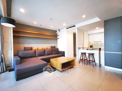 Modern living room with stylish furniture and open kitchen layout in a contemporary apartment.
