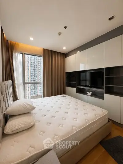 Modern bedroom with large window and built-in storage in urban apartment