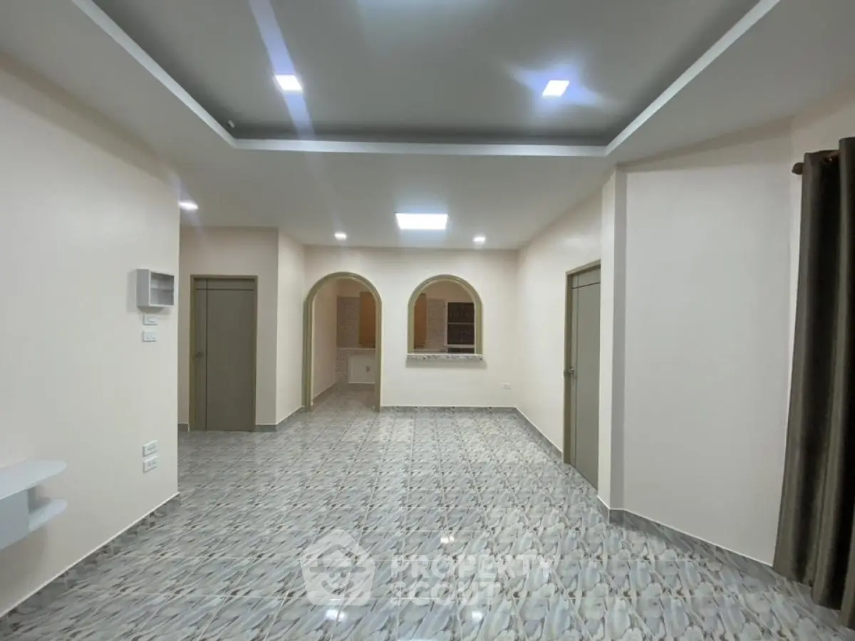 Spacious modern living room with elegant tile flooring and recessed lighting