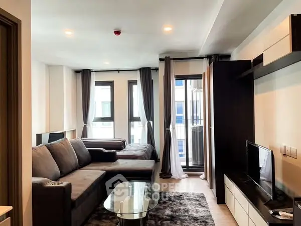 Modern living room with sleek furniture and large windows in a stylish apartment.