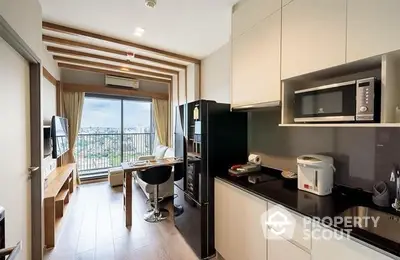 Modern kitchen with sleek cabinetry and appliances, opening up to a cozy dining area and a balcony with an impressive view.