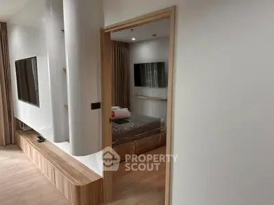 Modern apartment interior with sleek bedroom and living area, featuring contemporary design and neutral tones.
