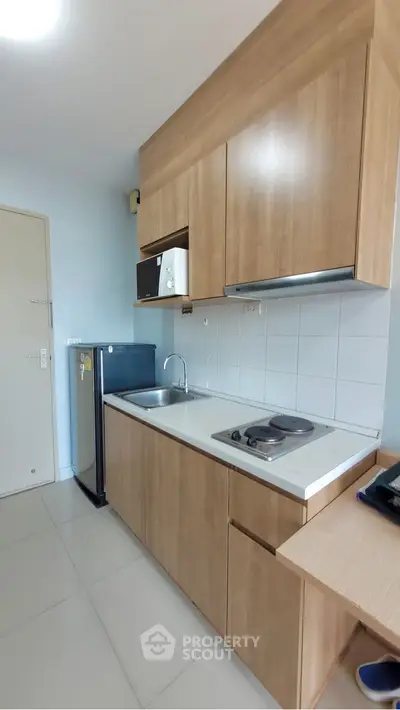 Modern compact kitchen with wooden cabinets and sleek appliances