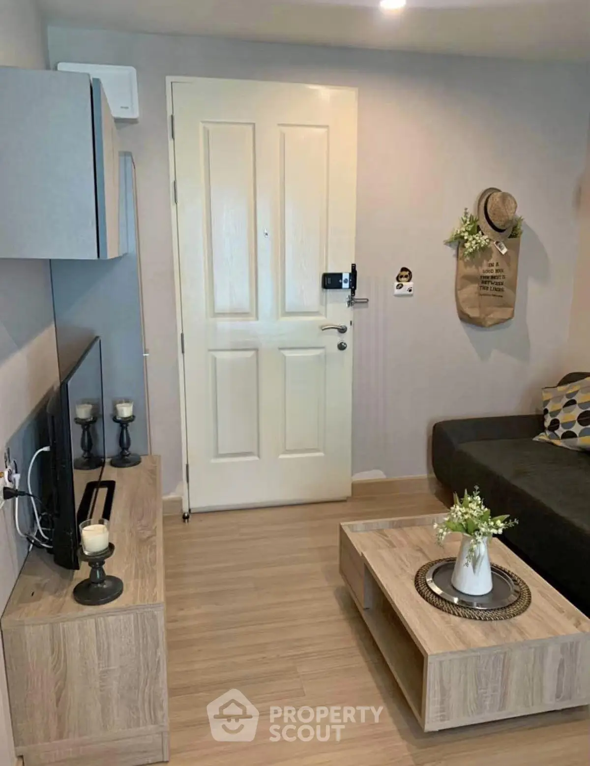 Cozy living room with modern decor and wooden flooring, featuring a stylish TV stand and comfortable seating.