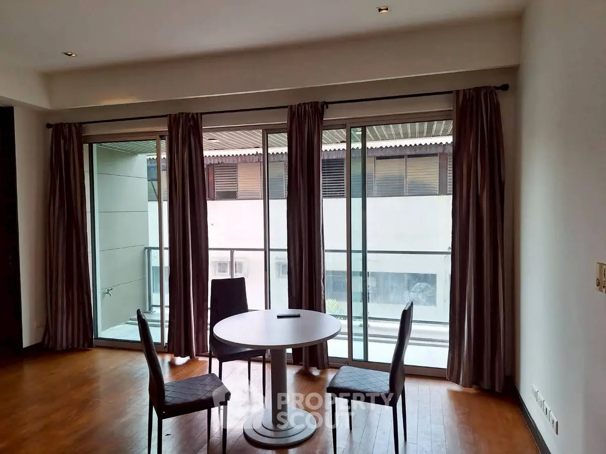 Spacious living room with large windows and balcony access in modern apartment.