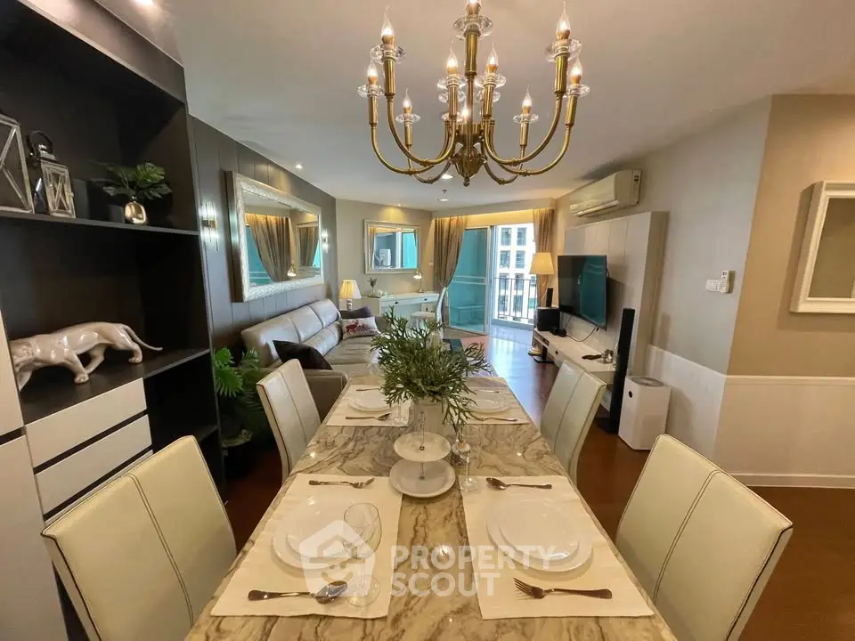 Luxurious dining and living area with elegant chandelier and marble table, perfect for entertaining.
