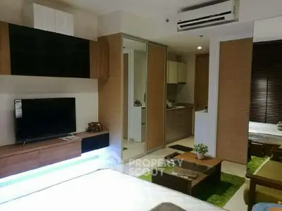 Modern living room with sleek furniture and open kitchen layout in a stylish apartment.