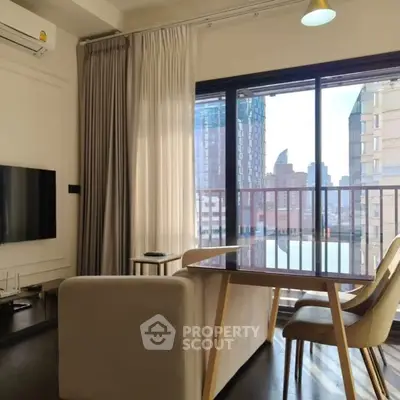 Modern living room with city view, featuring sleek furniture and large windows for natural light.