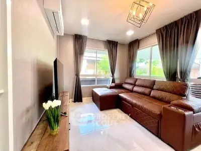 Modern living room with brown leather sofa and large windows offering natural light.