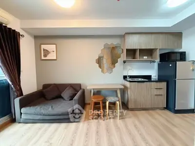 Modern living room with cozy sofa, stylish decor, and compact kitchenette in open layout.