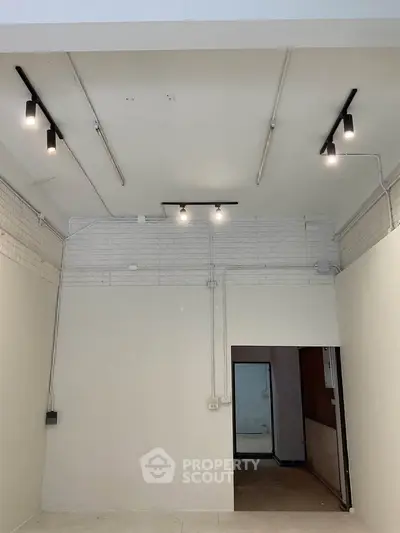 Spacious interior with high ceilings and modern lighting, ideal for creative workspace or studio.