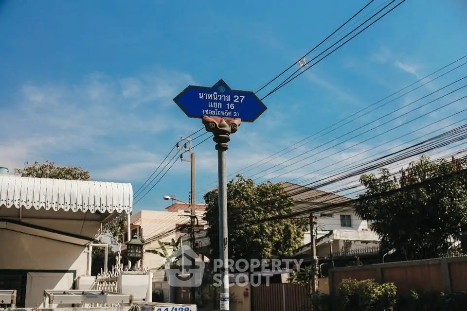 Charming residential street view with clear blue sky and lush greenery.