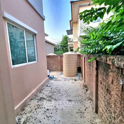 Narrow exterior alley with water tank and brick wall in residential area