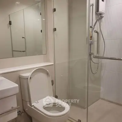 Modern bathroom with glass shower enclosure and sleek fixtures.