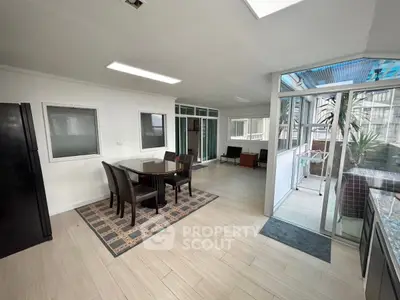 Spacious dining area with modern furniture and large windows for natural light.