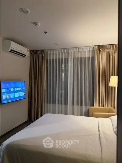 Cozy bedroom with modern decor and wall-mounted TV, perfect for relaxation.