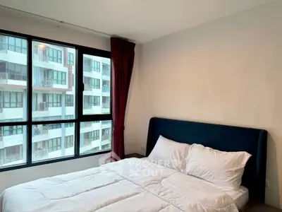 Modern bedroom with large window and city view in a stylish apartment