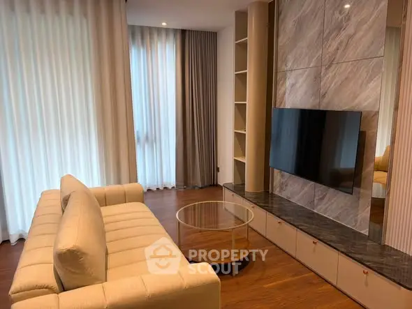 Modern living room with elegant sofa, wall-mounted TV, and stylish decor