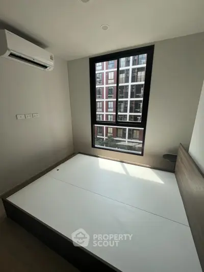 Modern bedroom with large window and air conditioning in urban apartment