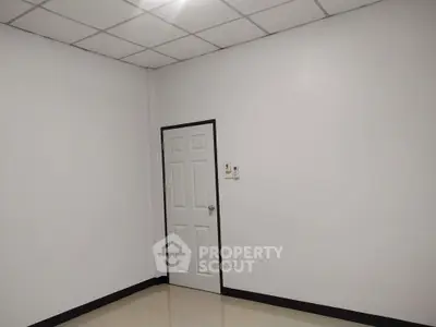 Minimalist empty room with white walls and door, ideal for customization.