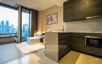 Luxurious open-plan living space with modern kitchen, high-end appliances, and panoramic city views through floor-to-ceiling windows.