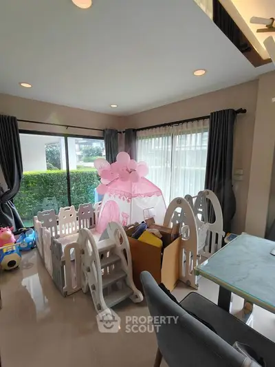 Charming family-friendly living room with play area and large windows.