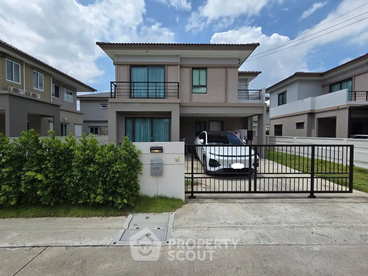 Modern two-story house with driveway and car, featuring a sleek exterior design.
