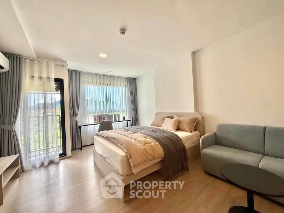 Spacious bedroom with modern decor and large windows offering scenic views.