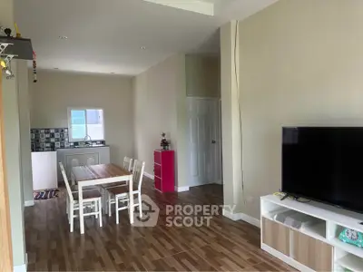 Spacious living area with dining table and modern TV setup in a cozy home.