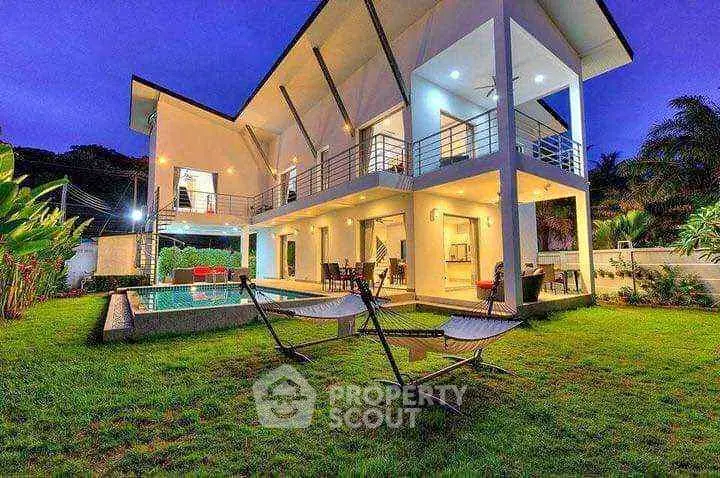 Luxurious modern villa with pool and spacious garden at dusk