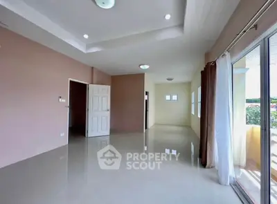 Spacious empty living room with large windows and glossy tiled floors