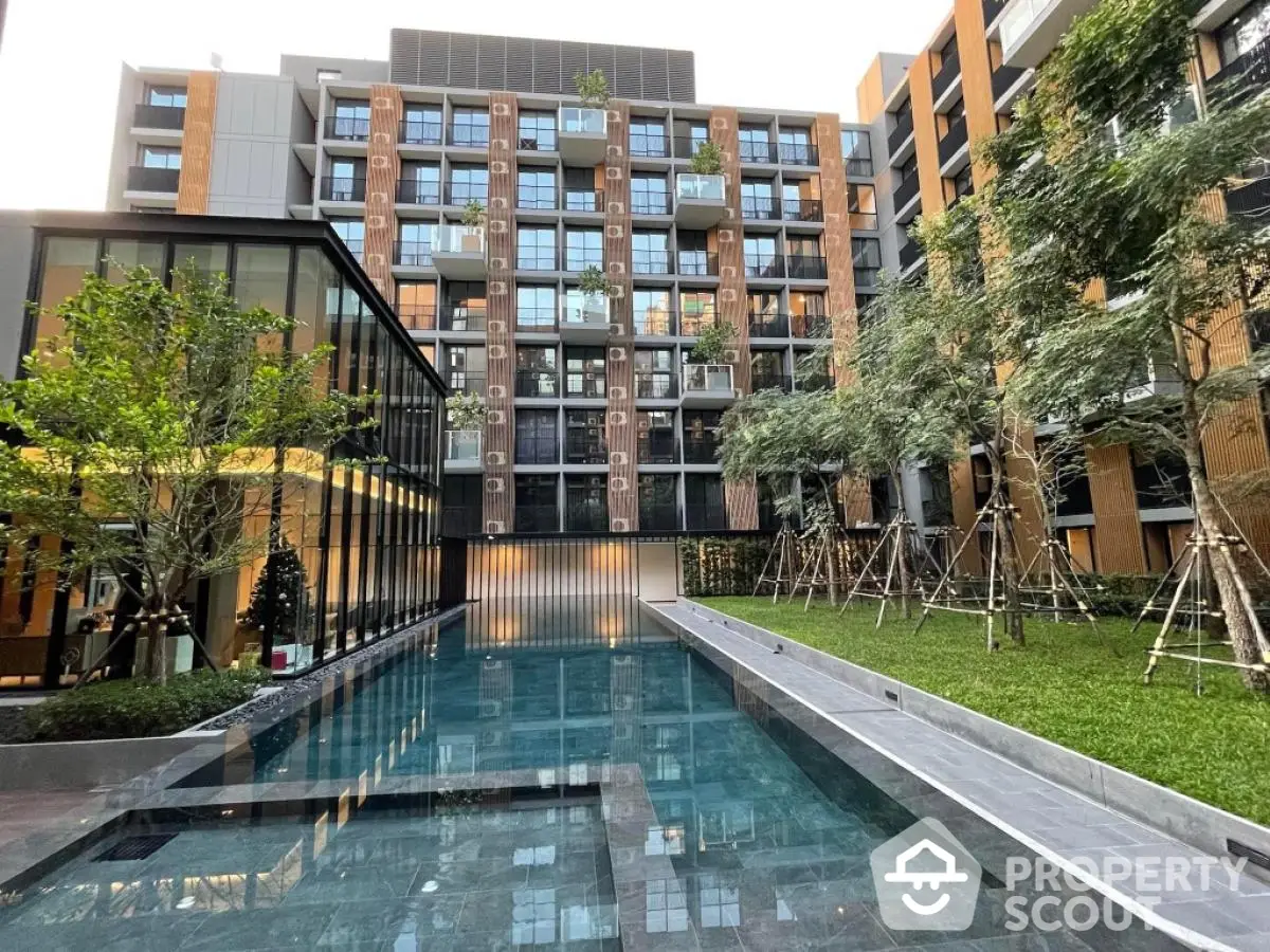 Modern apartment complex with pool and lush greenery, offering a serene urban living experience.