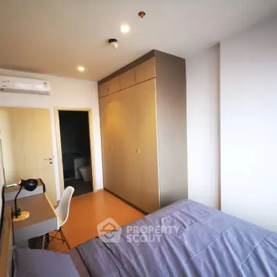 Modern bedroom with built-in wardrobe and study desk, featuring sleek design and ample natural light.
