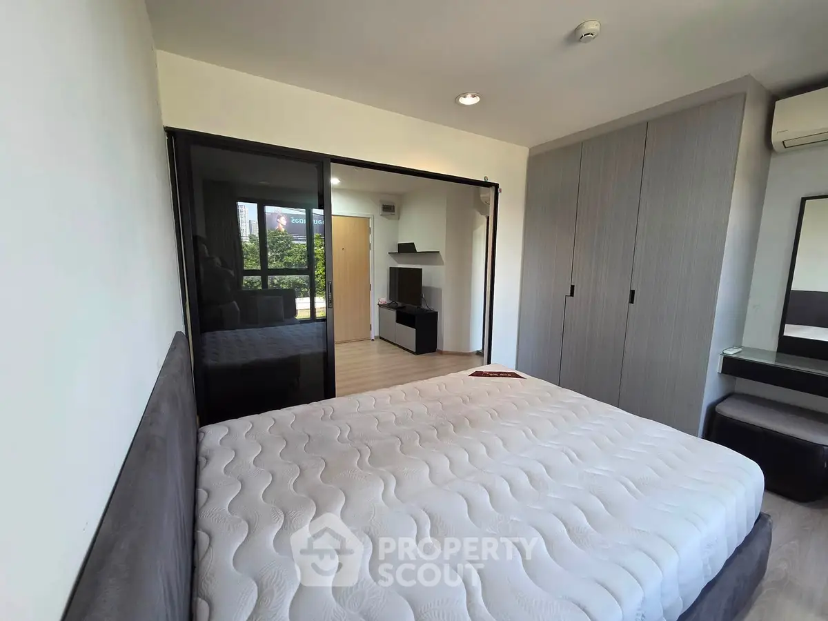 Spacious bedroom with modern design and ample natural light, featuring a large bed and built-in wardrobe.