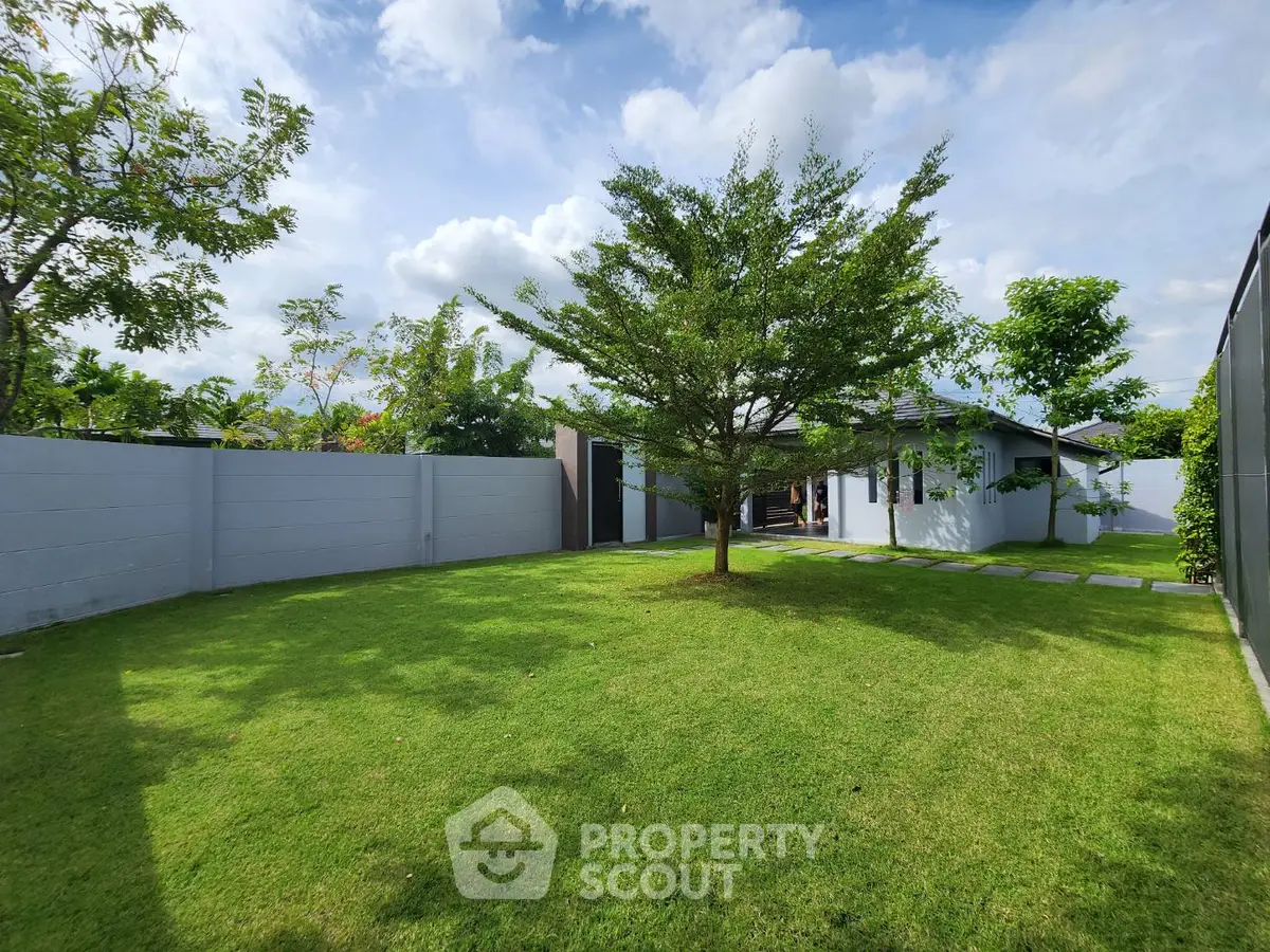 Spacious backyard with lush green lawn and modern house exterior