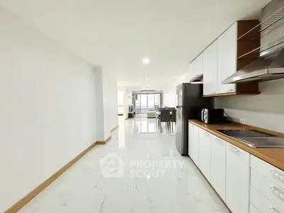 Spacious open-plan kitchen and dining area with modern appliances and sleek design.