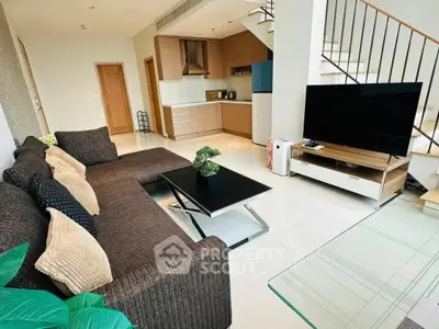 Modern living room with stylish furniture and open kitchen layout in a contemporary home.