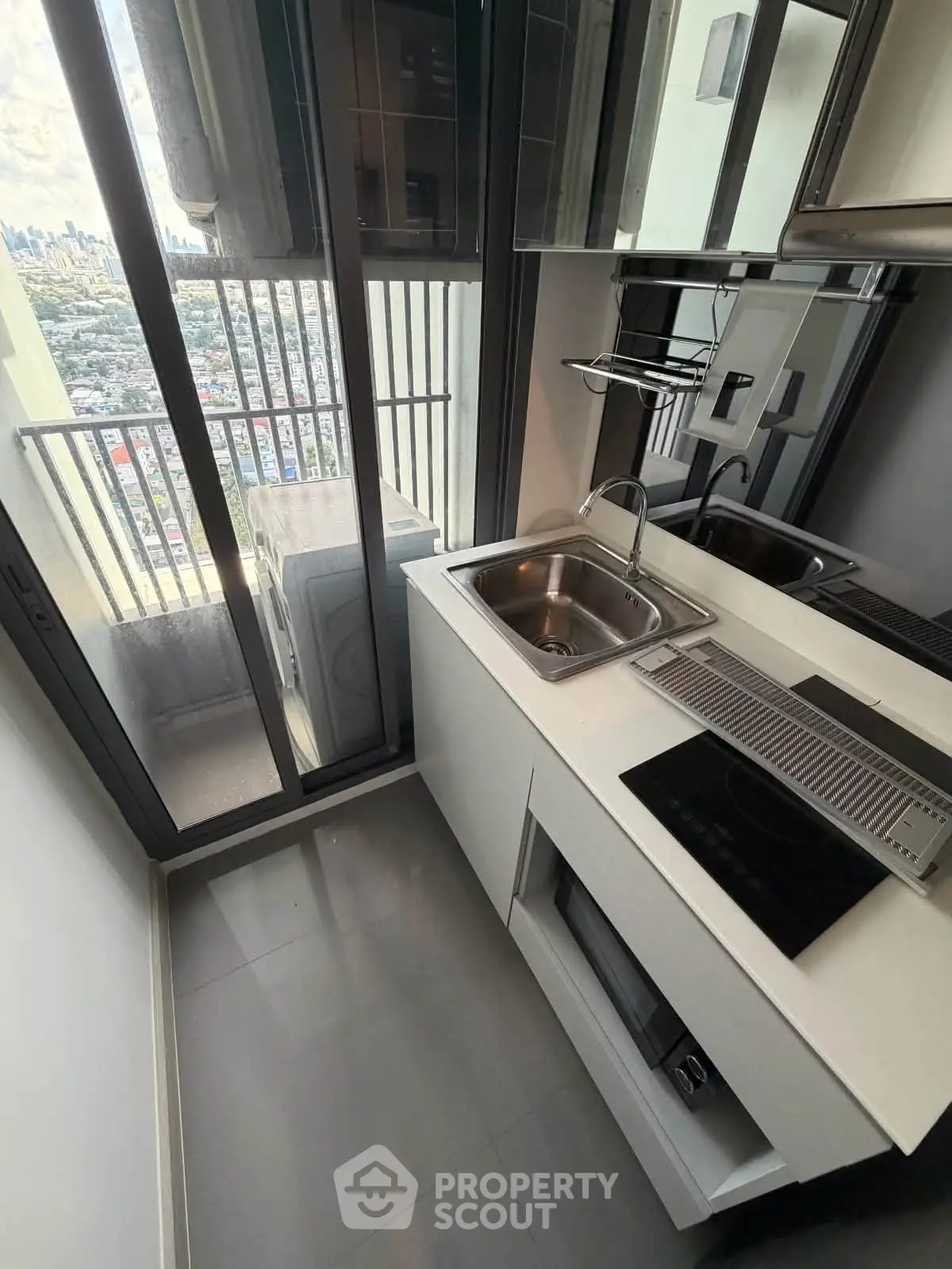 Modern compact kitchen with city view and sleek appliances