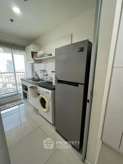 Modern kitchen with sleek appliances and city view from balcony.
