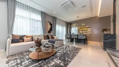 Luxurious modern living room with elegant decor and open dining area, featuring stylish furniture and ambient lighting.