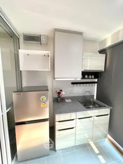 Modern compact kitchen with sleek cabinetry and stainless steel appliances