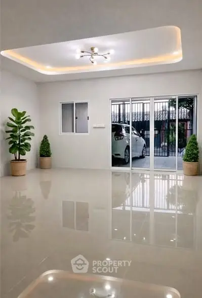 Spacious modern living room with glossy floors and sliding glass doors leading to a carport.