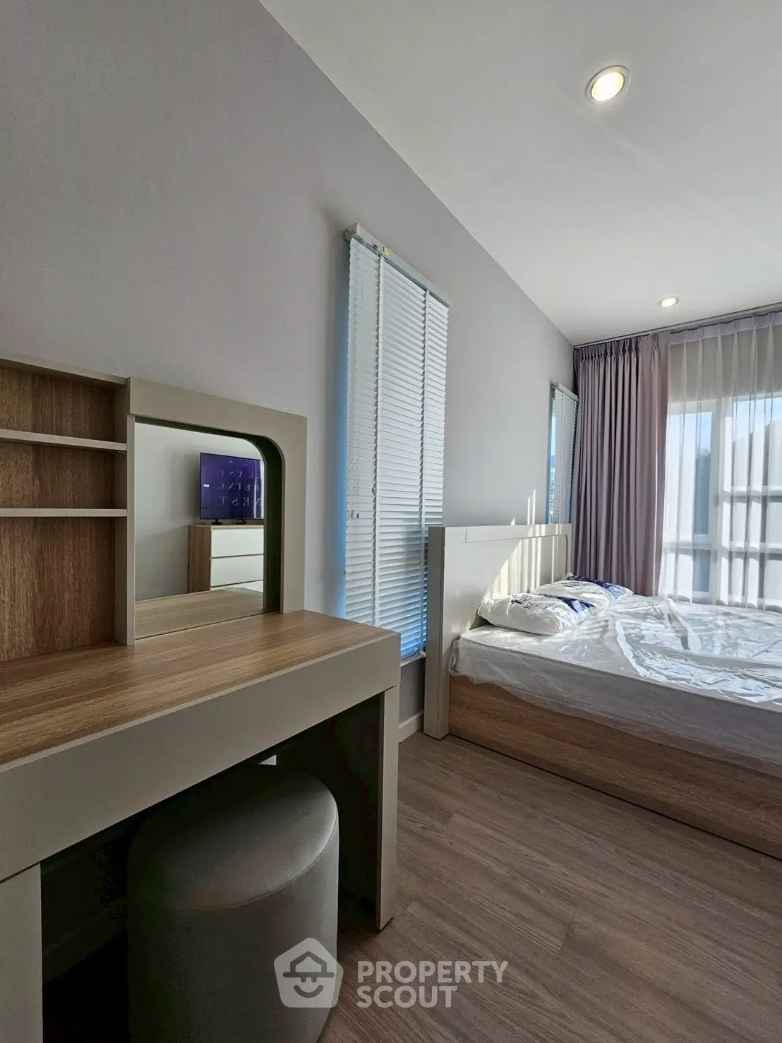 Modern bedroom with sleek furniture and large windows offering natural light.