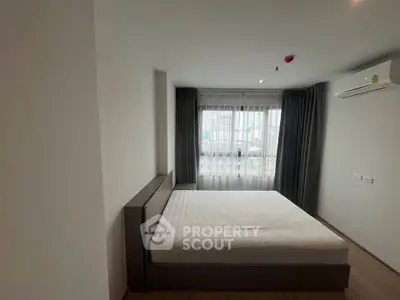Spacious bedroom with large window and modern air conditioning unit in a contemporary apartment.